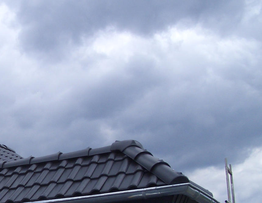 Ziegeldeckung auf dem Dachfirst unter einem bedeckten Himmel