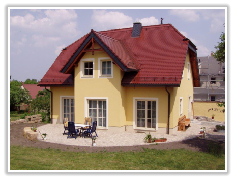 Gelbes Einfamilienhaus mit rotem Ziegeldach und Vordach