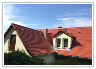 Rotes Ziegeldach eines Wohnhauses mit Dachfenster